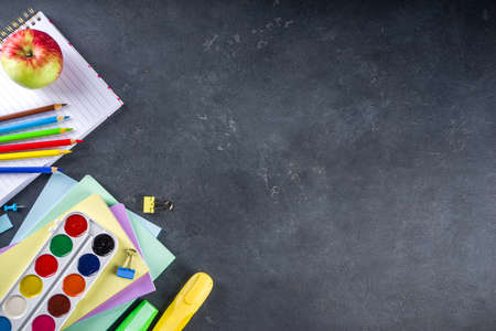 Back to school concept. Flatlay on dark blackboard background with various school office supplies and stationery, top view copy spaceの写真素材