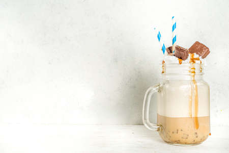 Set with different iced summer coffee drinks - espresso, frappe, latte, cappuccino, with whipped cream, syrup and crushed ice, in various glasses and mugs on white background copy spaceの写真素材
