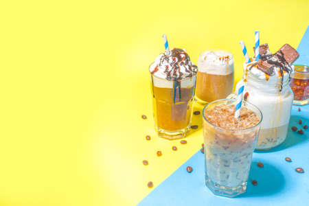 Set with different iced summer coffee drinks - espresso, frappe, latte, cappuccino, with whipped cream, syrup and crushed ice, in various glasses and mugs on white background copy spaceの写真素材