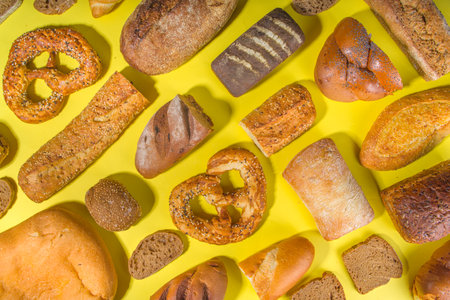 Assortment of various delicious freshly baked bread, on trendy bright background top view copy...