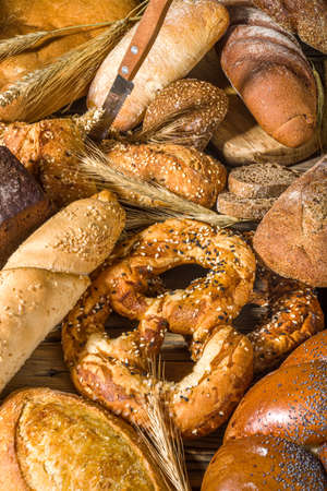 Assortment of various delicious freshly baked bread, on wooden rustic background copy space