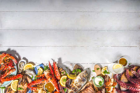 Assortment various barbecue Mediterranean grill food - fish, octopus, shrimp, crab, seafood, mussels, summer diet bbq party fest, with kebab, sauces, white wooden background, above copy spaceの写真素材