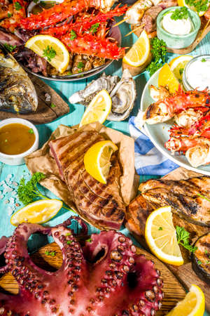 Assortment various barbecue Mediterranean grill food - fish, octopus, shrimp, crab, seafood, mussels, summer diet bbq party fest, with kebab, sauces, light blue sunne wooden backgroundの写真素材