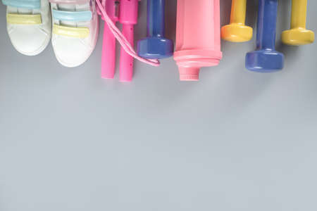 Woman fitness and sport concept background. Sneakers, jumping-rope, tape measure and dumbbells. Sport, fitness and healthy background. Spring spring return to fit. Top view flat lay copy spaceの写真素材