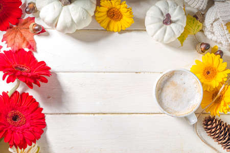 Cozy autumn background with hot coffee latte mug, with notepad, pumpkins, gerbera flowers, fall leaves. Thanksgiving day, Halloween greeting card, festive compositionの写真素材