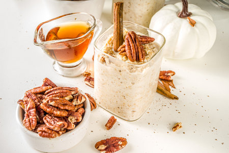 Spice autumn breakfast oats recipe, Homemade maple cinnamon overnight oatmeal with pecan nuts, maple syrup and spices, copy spaceの写真素材