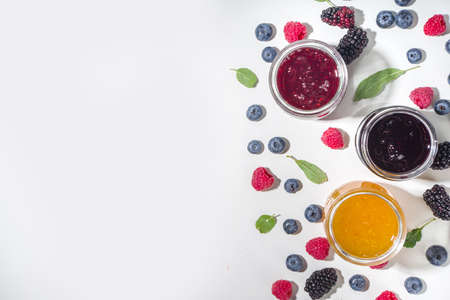 Assortment of summer seasonal berry and fruits jams in small jars, homemade preserving concept,...
