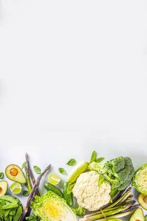 Healthy Diet Spring food background. Assortment of fresh raw organic green vegetables - broccoli, cauliflower, zucchini, cucumbers, asparagus, spinach, avocado, cabbage set on white backgroundの写真素材
