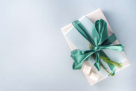Big stack of Christmas gifts with hot chocolate, stay on it like pedestal, cozy pastel colored craft...