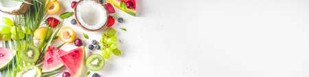 Assorted different summer tropical fresh raw fruits and berries. Clean eating, healthy lifestyle, diet and vitamin concept. Top view flatlay white table backgroundの写真素材
