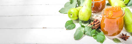 Homemade golden colored pear jam, with farm pears and leaves on white wooden background copy spaceの写真素材