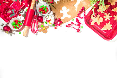 Christmas, New Year cooking background. Baking ingredients and utensils - gingerbread dough, cookie cutters, rolling pin. Making festive Christmas sweet cookies bright festive red white conceptの写真素材