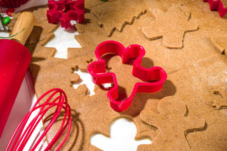 Christmas, New Year cooking background. Baking ingredients and utensils - gingerbread dough, cookie cutters, rolling pin. Making festive Christmas sweet cookies bright festive red white conceptの写真素材