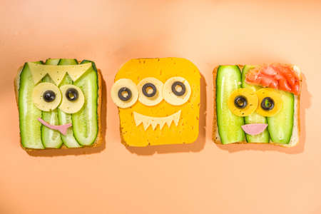 Various funny monster Halloween sandwiches. Set assortment creative breakfast snack toasts with cheese, Halloween kids party food, top viewの写真素材