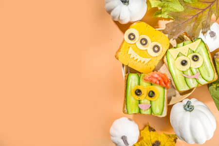 Various funny monster Halloween sandwiches. Set assortment creative breakfast snack toasts with cheese, Halloween kids party food, top viewの写真素材