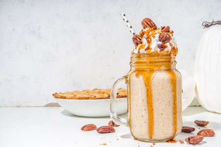 Pecan pie smoothie. Crazy shake cocktail with traditional autumn pie pecan flavor, white background copy spaceの写真素材