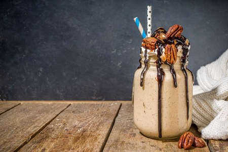 Pecan pie smoothie. Crazy shake cocktail with traditional autumn pie pecan flavor, wooden dark background copy spaceの写真素材
