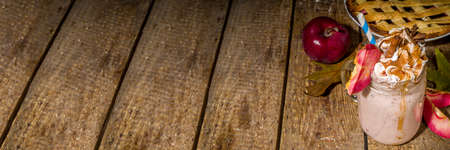Apple pie smoothie. Crazy shake cocktail with traditional autumn apple pecan flavor, wooden dark background copy spaceの写真素材