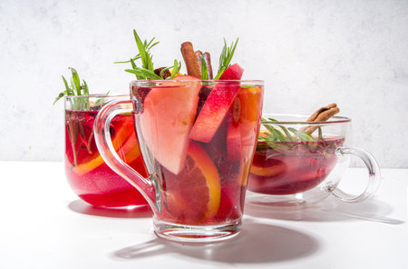 Homemade mulled wine cocktail. Various glass mugs with classic winter hot spicy mulled wine, with ingredients on white background flatlay top view copy spaceの写真素材
