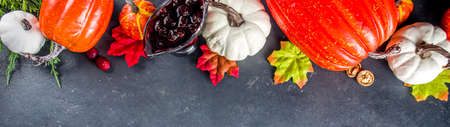 Festive thanksgiving day holiday background. White orange pumpkins, colorful autumn leaves, berries, on dark concrete background top view frame copy spaceの写真素材