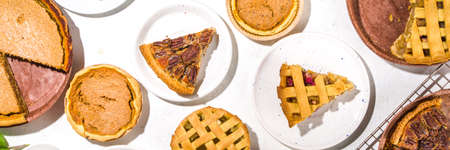Set variety autumn pies. Pecan, apple, pumpkin small tart cakes and pies on concrete background with...