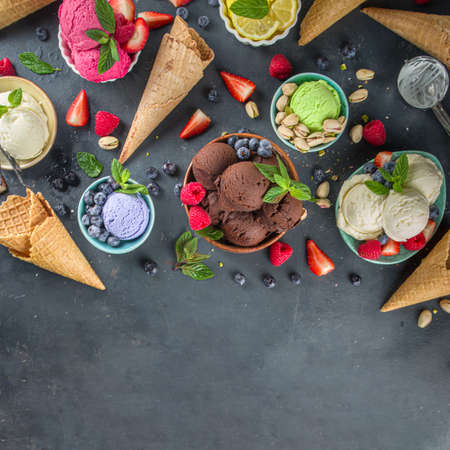 Various colorful ice cream balls in different bowls, with ice cream waffles cones and flavor...