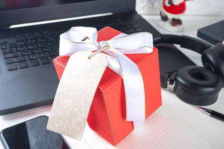 Secret Santa. Christmas celebration in office. Office desk with laptop, notepads, office supplies,...