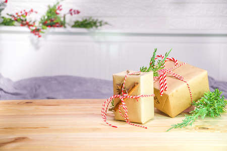 Christmas gift boxes on wooden table in festive decorated room background copy spaceの写真素材