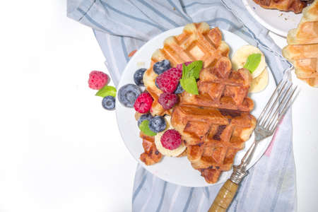 Modern dessert croffle - mixture of croissants and waffles, puff baking waffle iron pan, with berry, fruit cocolate toppingの写真素材
