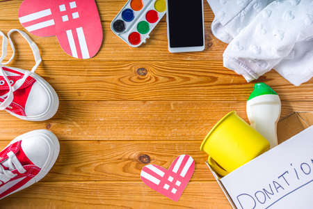 Donation Box with various give goods for Giving Tuesday, with red heart logo. Charity. Collect unwanted waste goods, pass it poor needy people concept. Participating in international donation drive.の写真素材