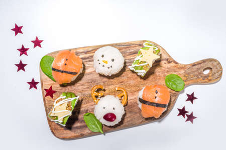 Christmas sushi set with funny decorated rolls like Xmas symbols - santa, deer, snowman, fir tree, Christmas sushi bar menu, festive delivery mock-upの写真素材