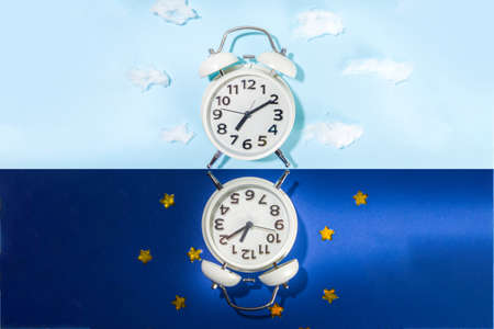 Circadian rhythms with white alarm clock, night and day backgrounds flatlay copy spaceの写真素材
