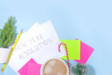 2022 new year resolution concept. Notepad with copy space for your year plan and action list, holiday decoration, latte coffee cup on high-colored blue background flatlay top view copy spaceの写真素材