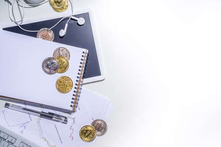 Bitcoin coins on office desktop workspace. Working with cryptocurrency markets concept. Keyboard,...
