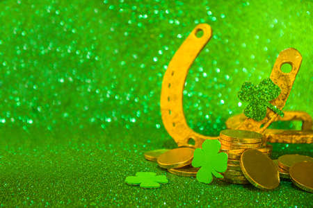Saint patrick's day greeting background. Patrick's day sale, invitations template, menu. With holiday symbols - golden horseshoe, green clover, leprechaun hat, gold coins, green bokeh backgroundの写真素材