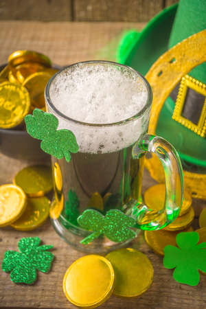 St Patrick's Day Pub Bar menu background. Green Beer In Glass with And with horseshoe, shamrock clover decor, gold coins, on green bokeh glittering background. St Patrick's holiday greeting card mock upの写真素材