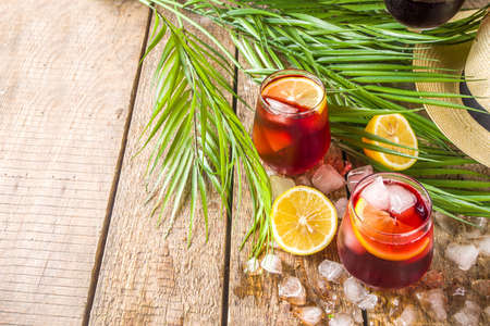 Tinto de Verano or vino de verano, Spanish Wine Cocktail. Refreshment acoholic drink sangria. Cool iced alcohol beverage with lemon juice and slices, wooden background with summer tropical decor copy spaceの写真素材