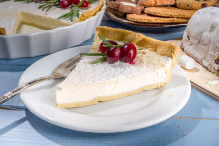 Homemade Christmas pastries, sweet cheesecake pie with powdered sugar, cranberries and rosemary. Christmas and New Years festive baking backgroundの写真素材