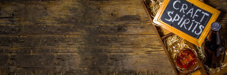 Craft spirit alcohol. Various bottles and glass with hand crafted hard strong alcohol drinks. Old wooden rustic background copy spaceの写真素材