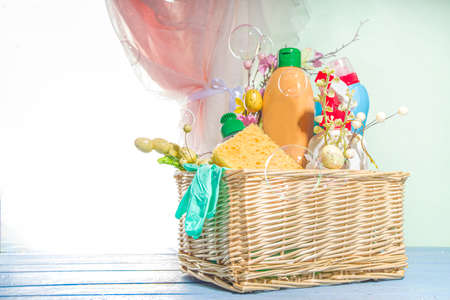 Spring cleaning concept. Sun lighted background near open window with bucket or basket with cleaning...