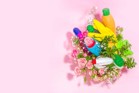 Creative bright spring cleaning concept. Tools, bottles, accessories for cleaning house with spring flowers and leaves hang on clothesline, box, bright sunny light copy spaceの写真素材