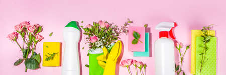 Creative bright spring cleaning concept. Tools, bottles, accessories for cleaning house with spring flowers and leaves hang on clothesline, box, bright sunny light copy spaceの写真素材