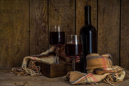 Winter wine tasting degustation background. Craft wine bottle with two glasses over wooden...