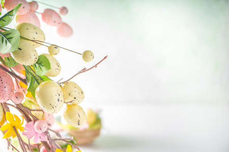 Easter greeting card background. Spring tree decor branches with colorful eggs, flowers and leaves...