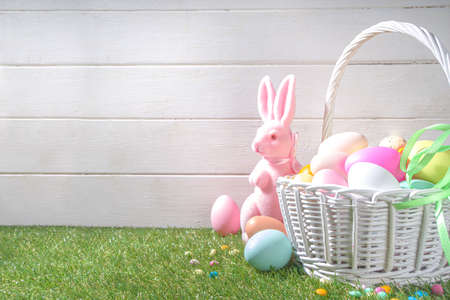 Easter background. Vase with a bouquet of tulips flowers, Easter eggs and bunny rabbits decor. On...