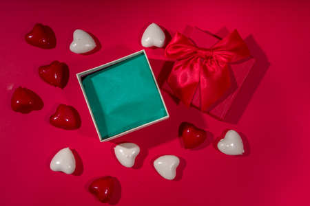 Valentine's Day holiday background. Craft paper gift box with ribbon, rose flowers and hearts decor,...