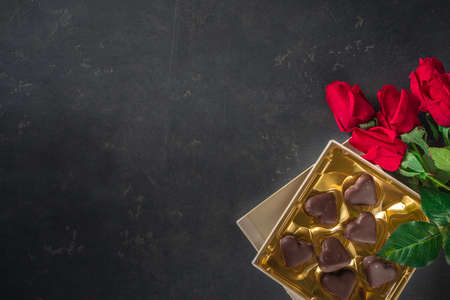 Valentine day background with Chocolates Hearts and Red Roses. Over Black Stone table Backdrop, top viewの写真素材