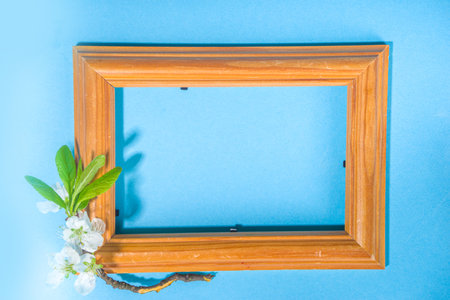 Happy Easter Spring Holiday Greeting Card Background with Easter colorful eggs, decorative bird nests and blossom spring garden flowers, flatlay copy space on high-colored blue backgroundの写真素材