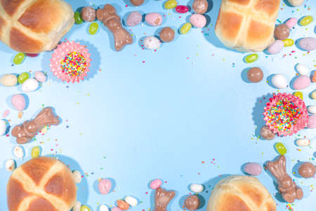 Bright high-colored Easter festive background. Blue background with traditional Easter sweets - hot...