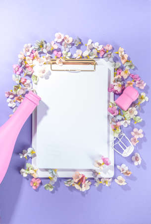 Mother day, Birthday, 8 march, Spring holiday background with spring blossom flowers, pink colored champagne bottle, on violet very peri color background flatlay mockup with notepadの写真素材